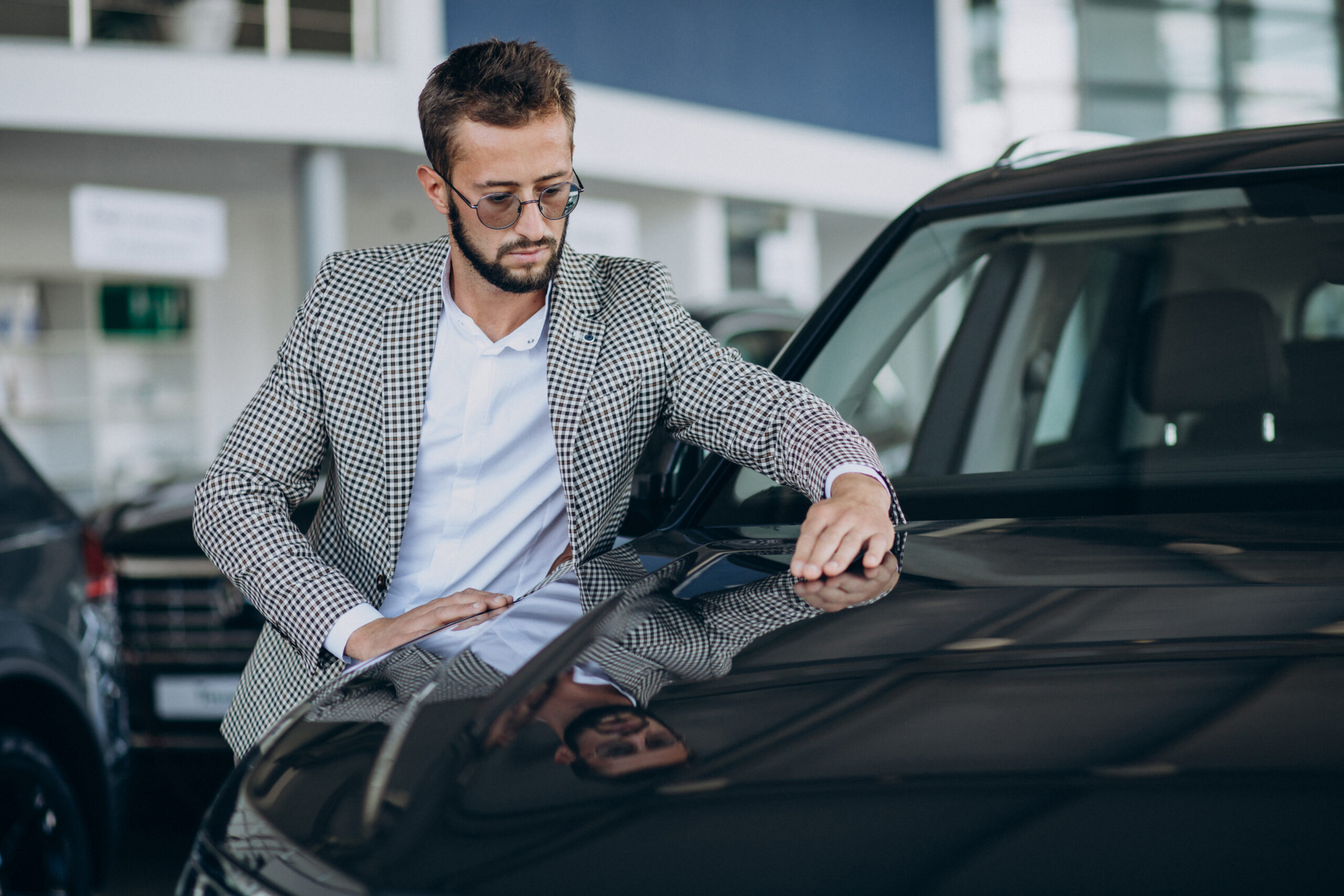 Business man choosing a car in a car showroom